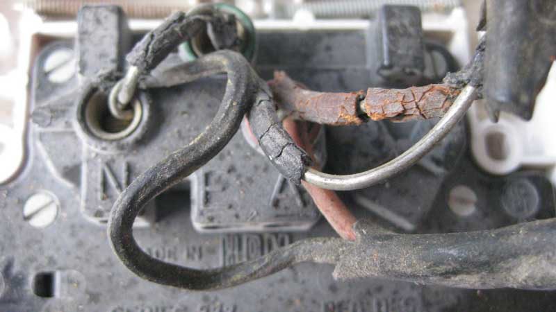 Fig. 1: Degraded rubber insulated wiring behind a power point in a 70 year old house.