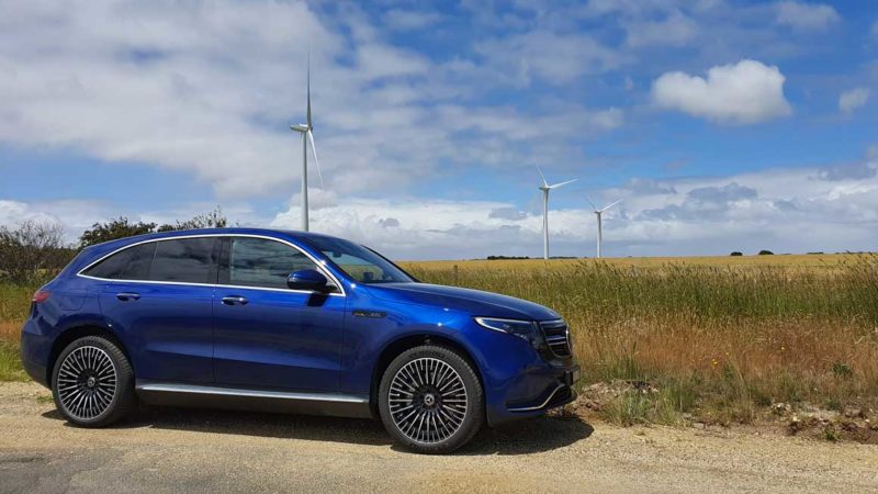 Mercedes EQC400 in front of wind turbines