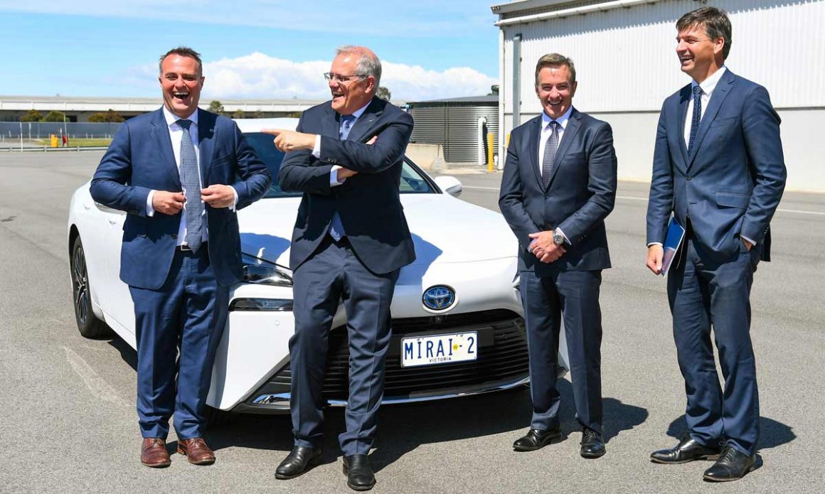 Tim Wilson, Prime Minister Scott Morrison, Toyota Australia president Matthew Callachor and Minister for Energy Angus Taylor pose for a photo with a hydrogen-fuelled car in Melbourne. (AAP Image/Pool, William West)