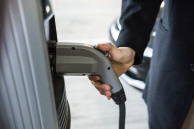 Close-up of man charging car at electric vehicle charging station, free pik